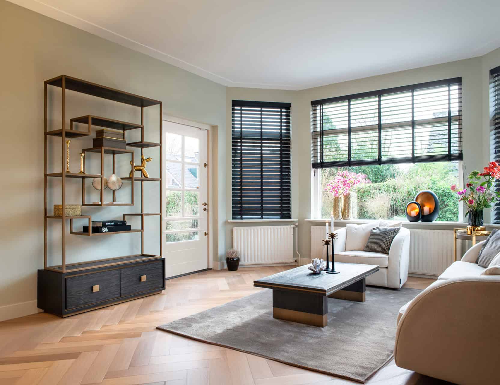 Eigentijdse woonkamer met zwart-witte raamdecoratie en stijlvolle interieurdecoraties voor een modern interieur.
