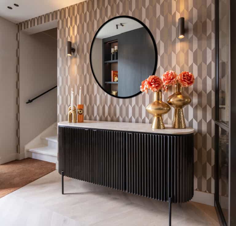 Moderne binnenhuisarchitectuur met zwarte sideboard en decoratieve vazen in goud en roze.