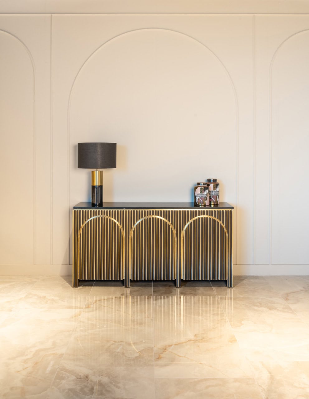 - Gedecoreerde gouden en zwarte console tafel met lamp en decoratieve items.