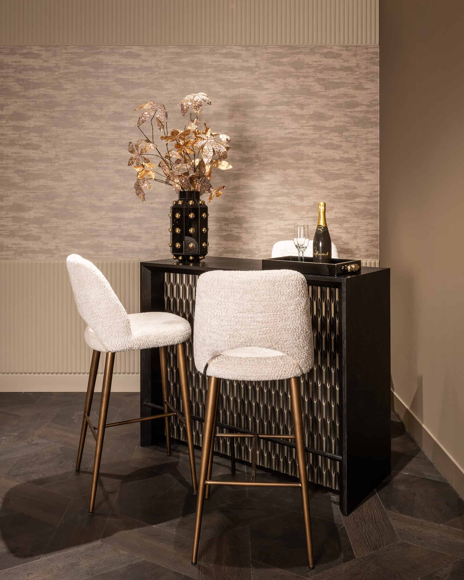 Elegante bar met luxe decor, zwarte kast en gouden details, perfect voor interieur en woonaccessoires.