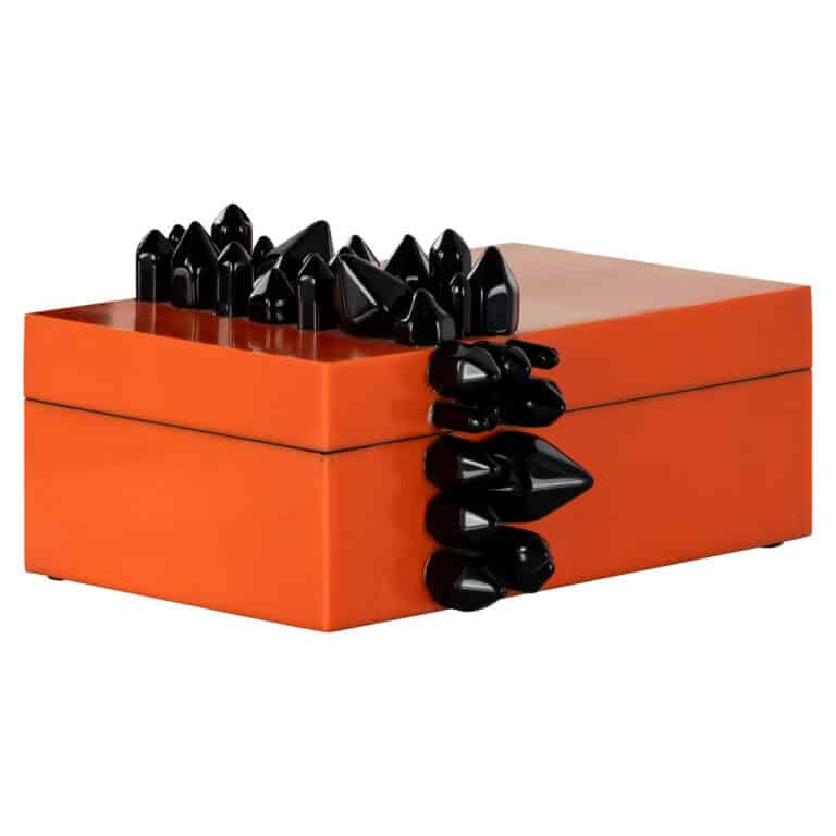 Kunstzinnige sierkist met zwarte stenen en oranje deksel, modern interieuraccessoire.