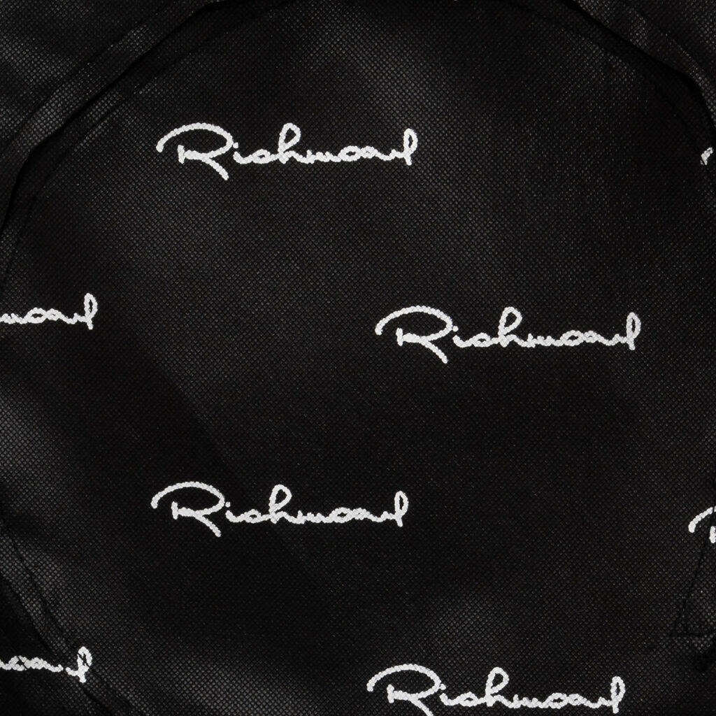 Close-up van tas met Richmond Interiors logo in wit op zwarte achtergrond.