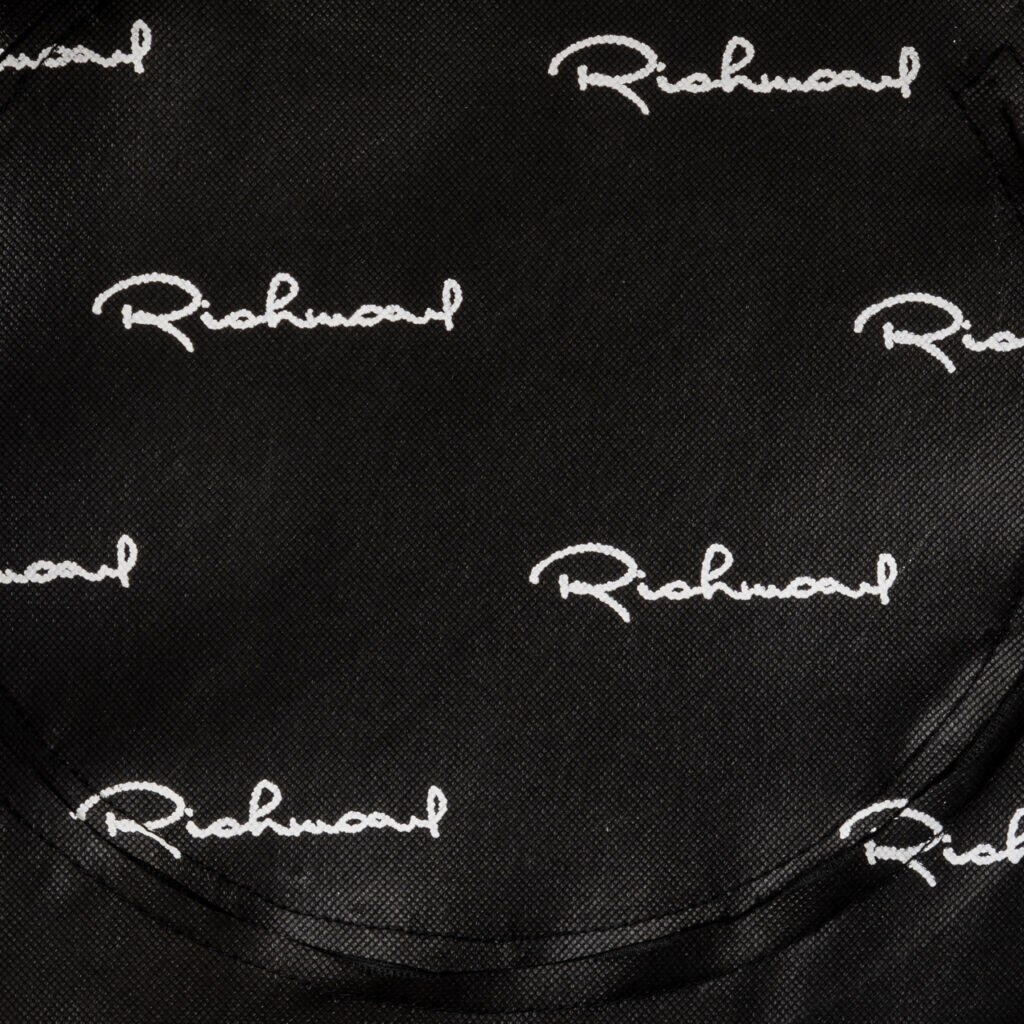 Richmond Interiors logo op zwart textiel, branding en design.