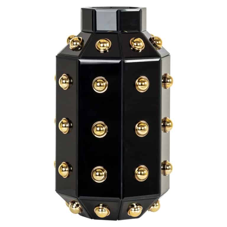 Decoratief zwart en goud object met ronde gouden details.