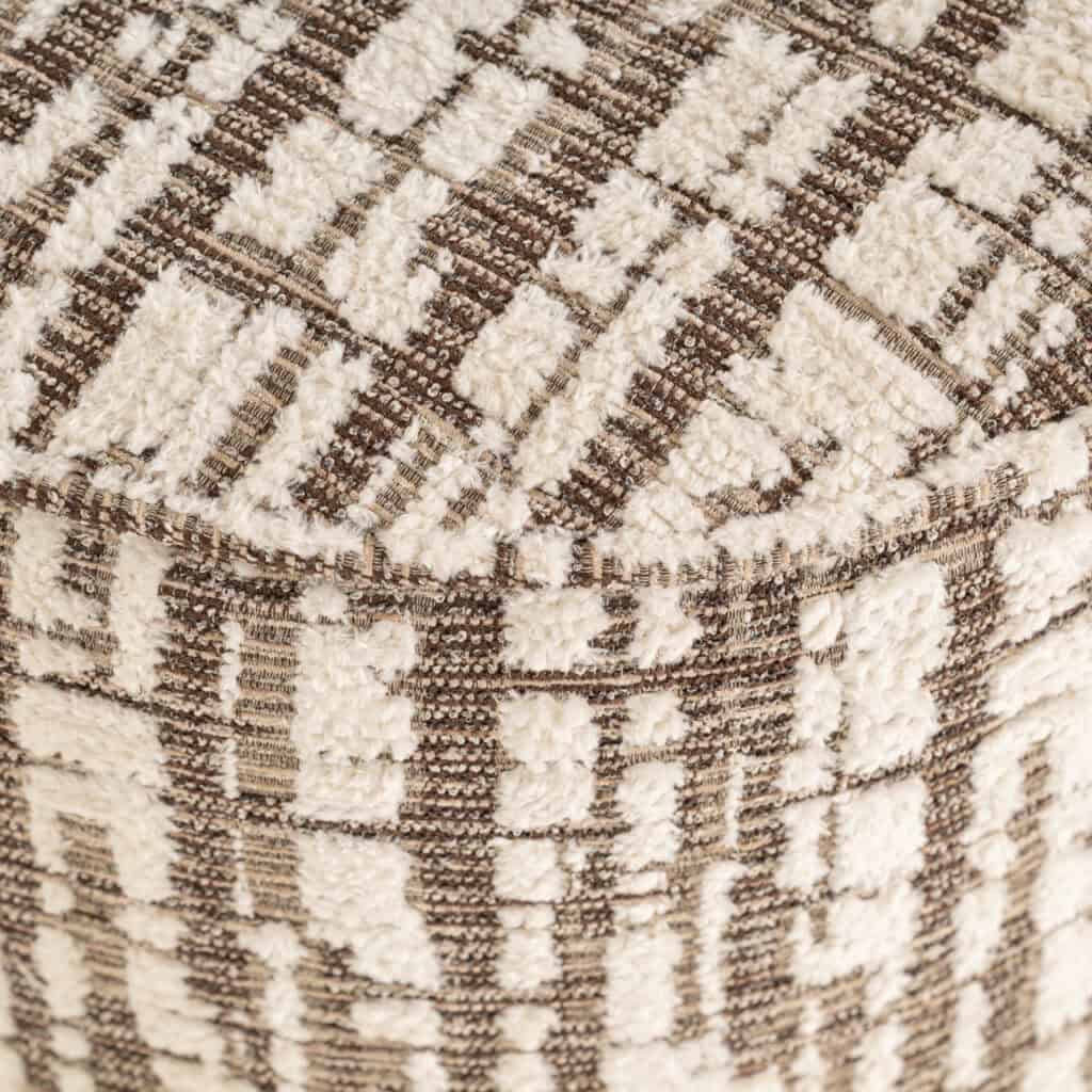 Geometrisch gestoffeerde bank met luxe textuur en moderne uitstraling.
