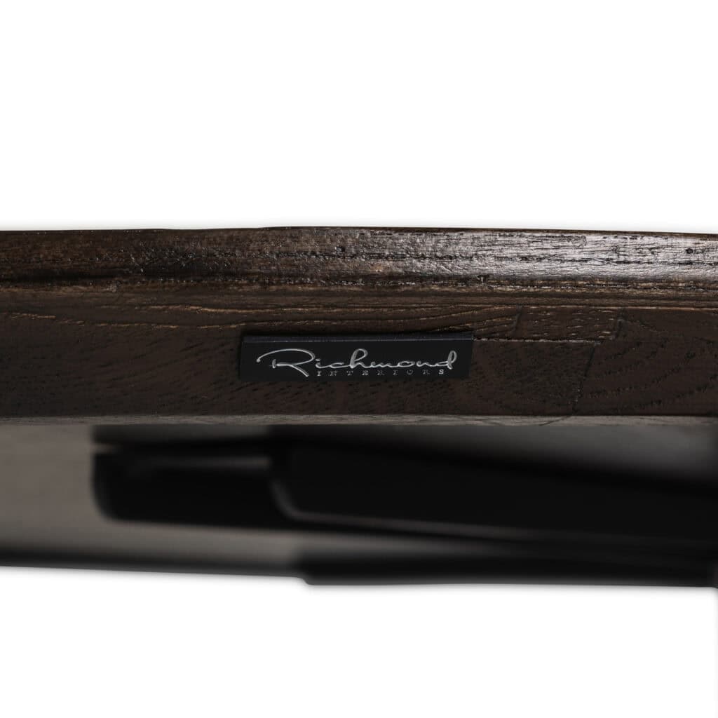 Richmond Interiors logo op een houten meubelstuk, focus op branding en interieurdesign.