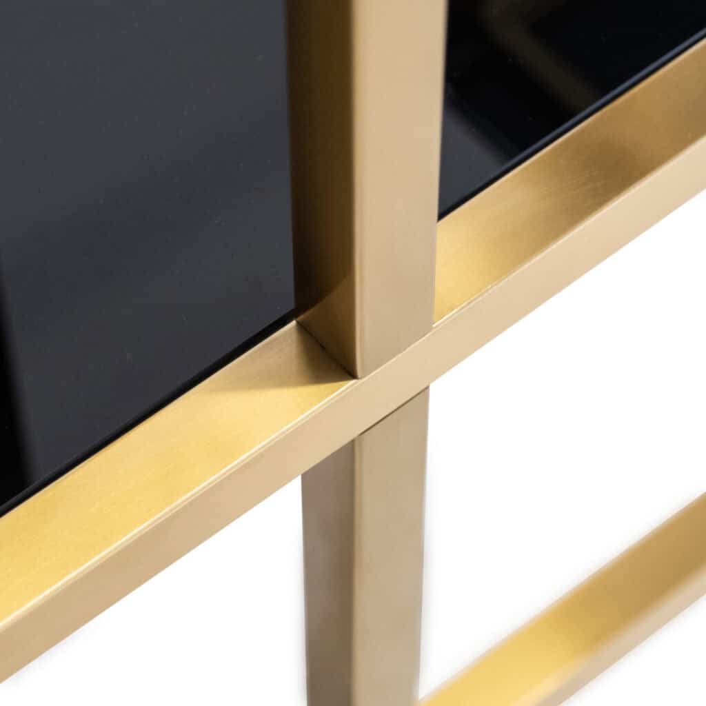 Luxe wandkast met brushed gold afwerking en zwarte deuren.