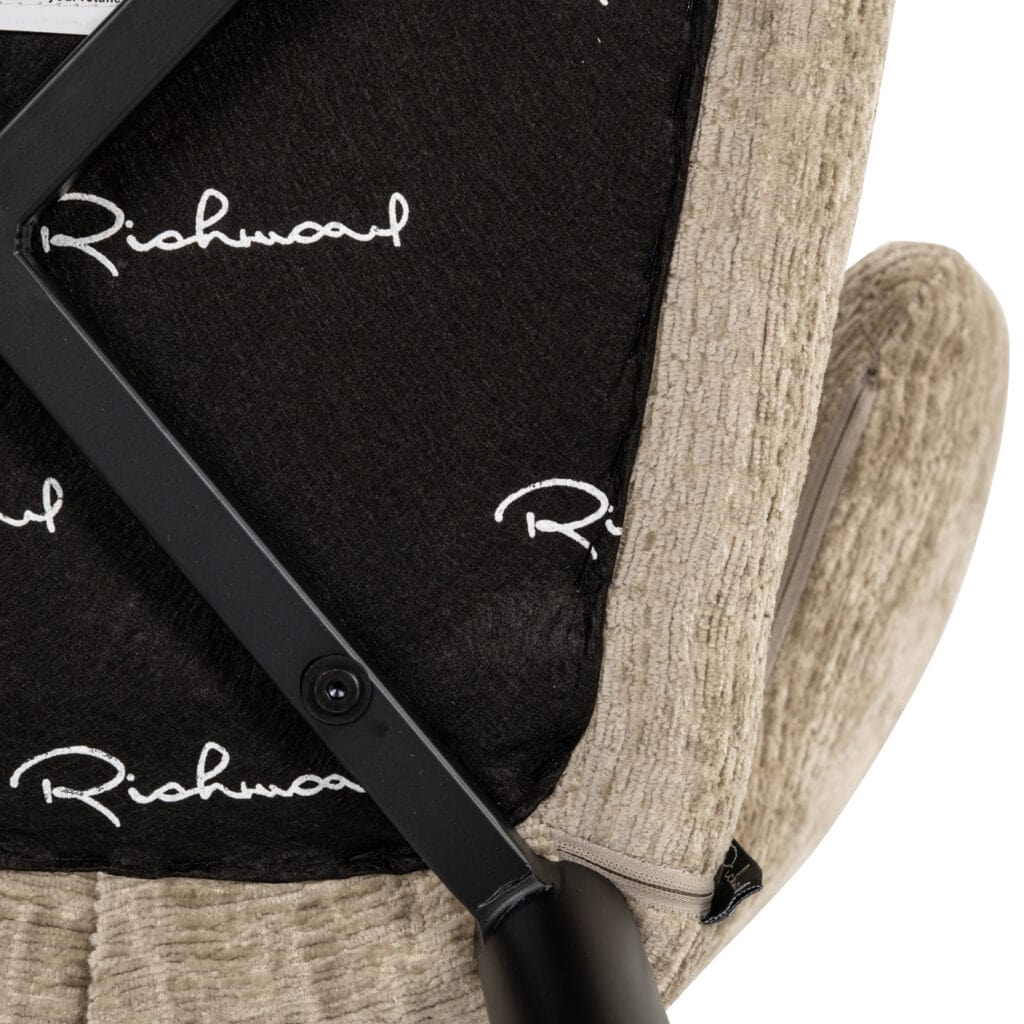 Dichtbijzicht van een beige stoel met zwart rugleuning met Richmond logo.