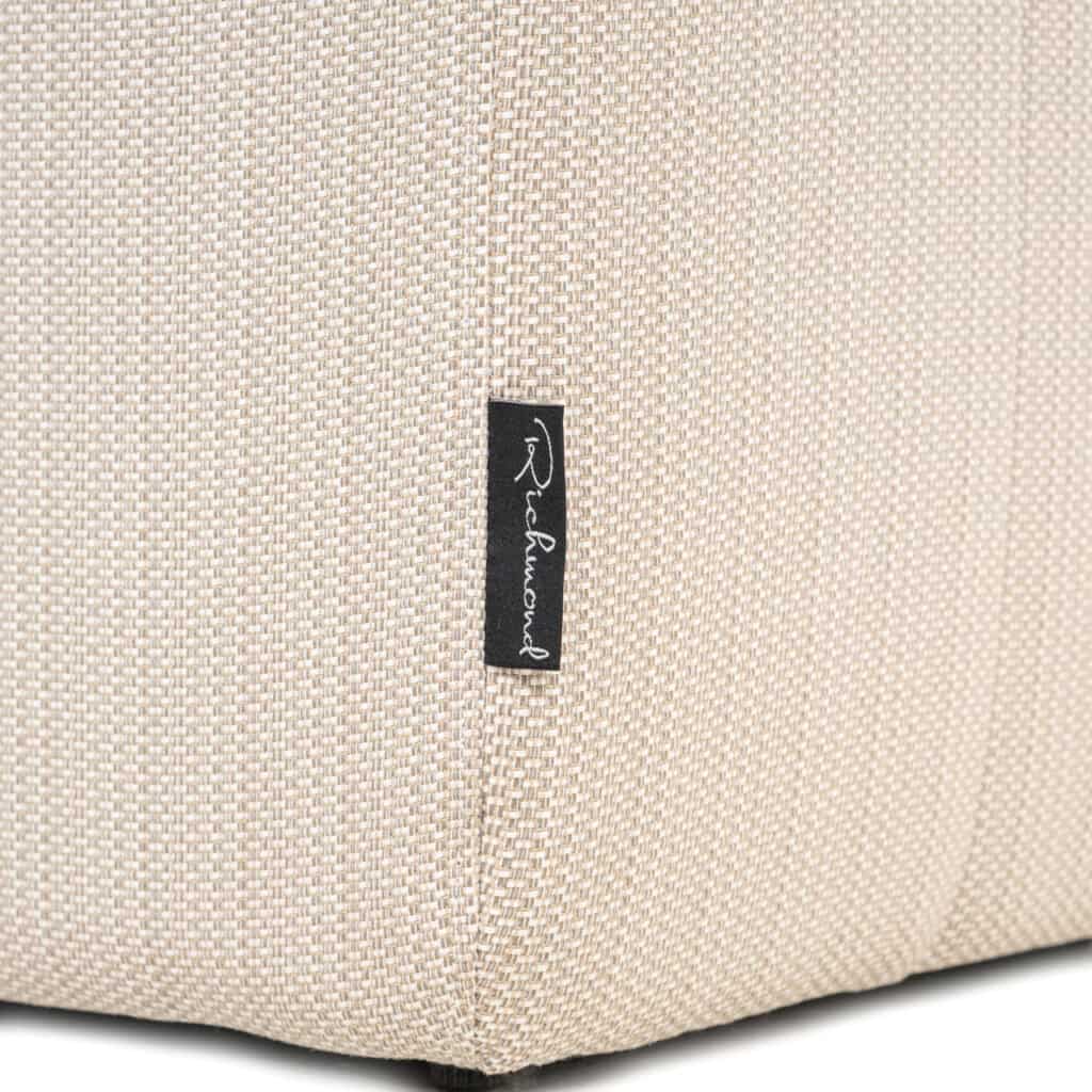 Nabij close-up van een beige meubelstuk met Richmond logo.