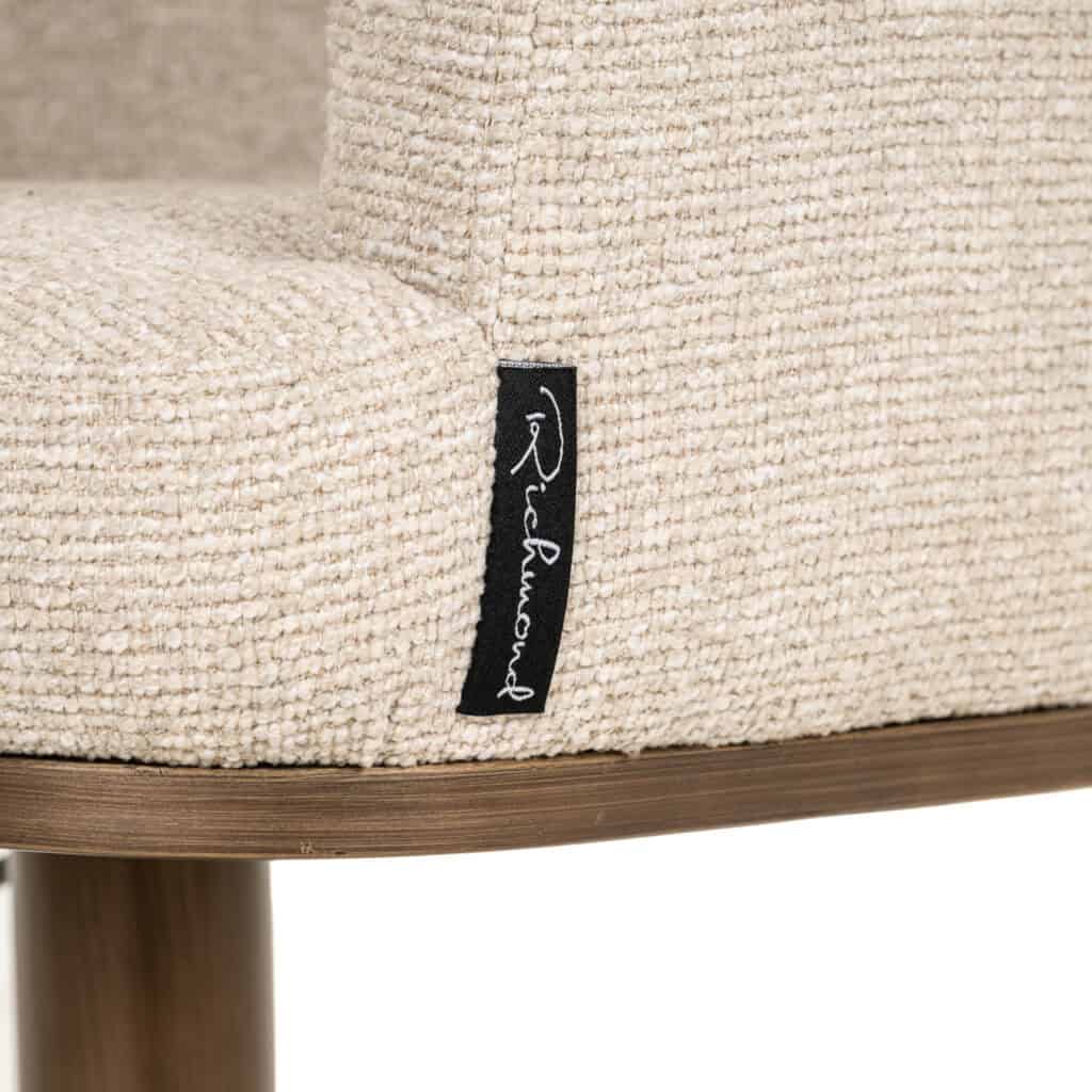 Dichtbijzicht van een beige stoffen fauteuil met Richmond label.