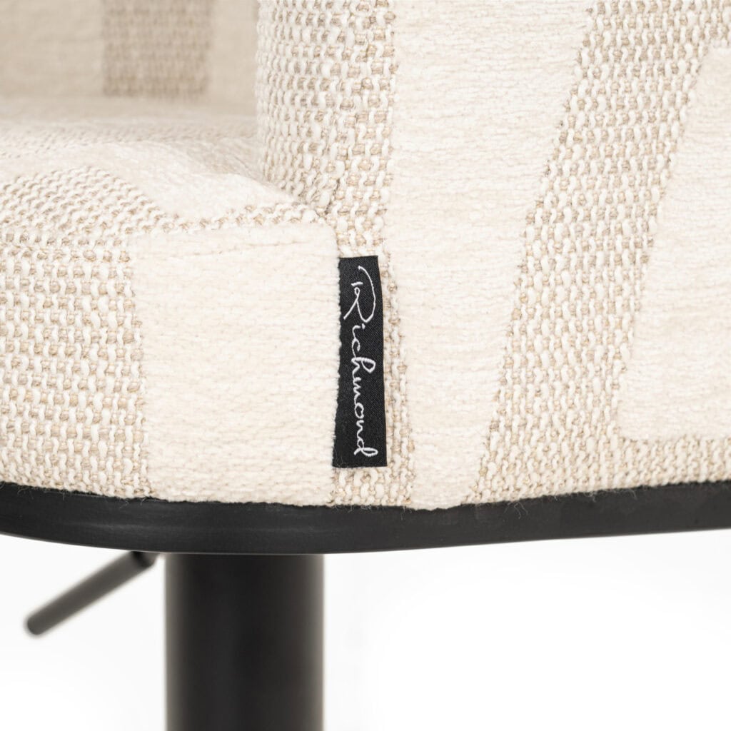 Modern beige upholstered chair with a black base and label.
