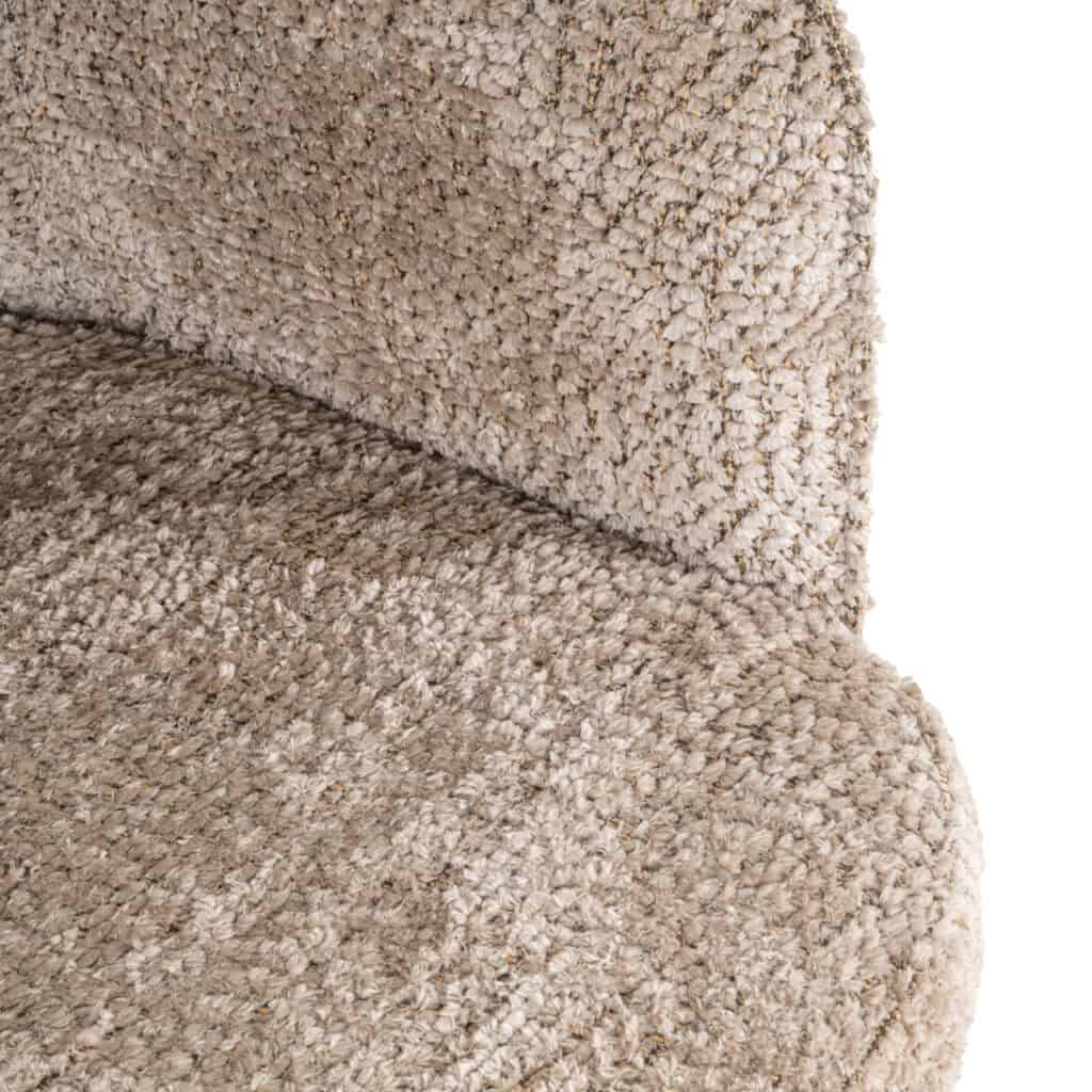 Gros plan sur la chaise de salle à manger Delphina, recouverte d'un tissu doux et naturel.