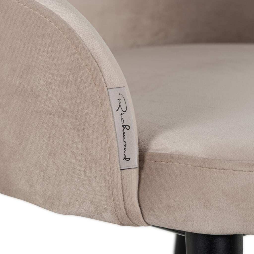 Luxe beige zitkamerstoel met merklabel voor elegant interieur.