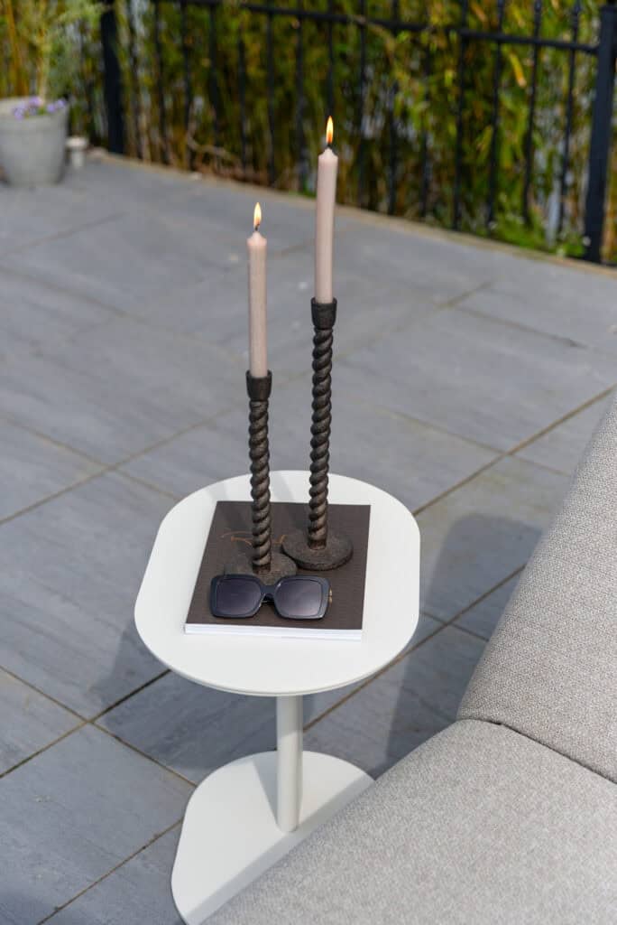 Decoratieve kaarsen en accessoires op terras met moderne sfeer.