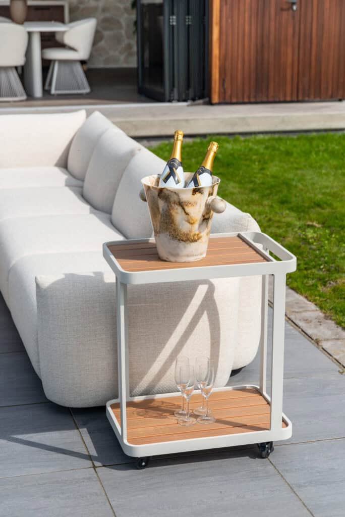 Salon extérieur avec champagne des verres posés sur une table d'appoint, salon de jardin élégant.