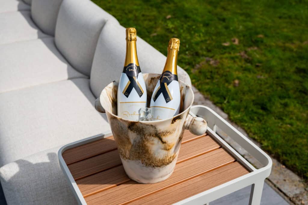 Comfortabele buitenbank met champagnekoeler voor stijlvolle tuinfeesten.