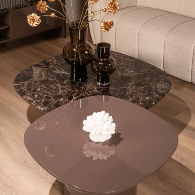 Stijlvolle woonkamer met marmeren en glazen tafels en decoratieve vazen.