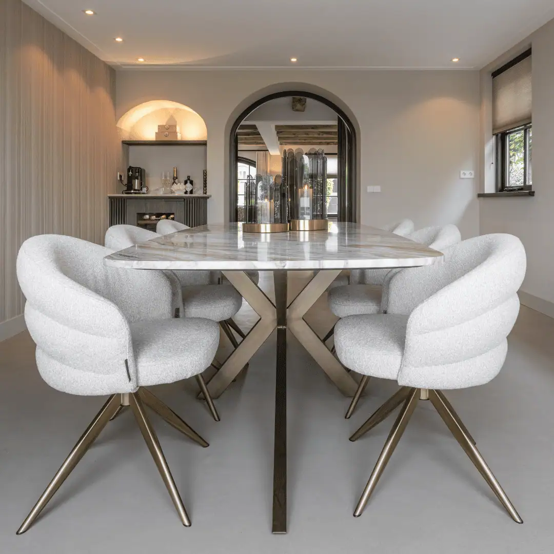 Modern dining area with eight light gray chairs and a marble table at Richmond Interiors.