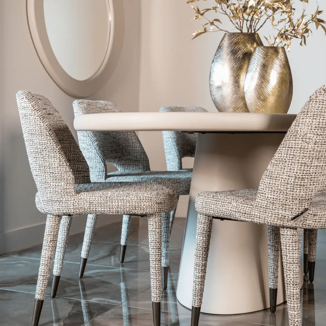 Moderne eettafel met vier gestoffeerde stoelen en decoratieve vazen.