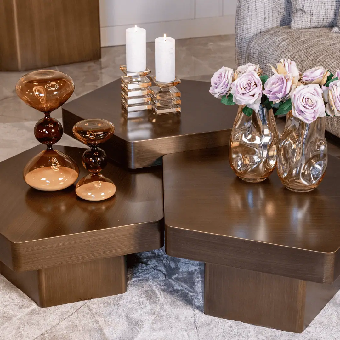 Un salon élégant avec des tables basses en bois, des fleurs et des bougies.