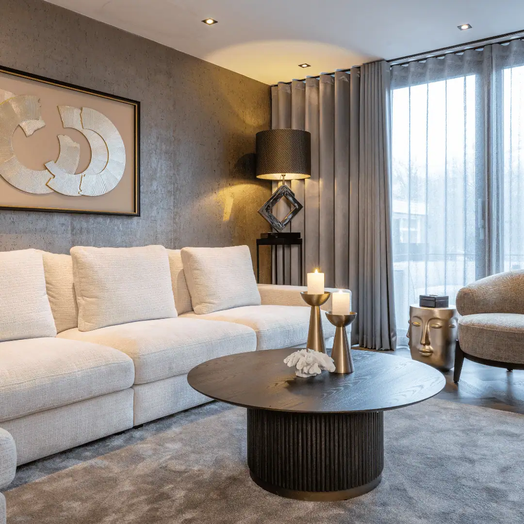 Luxurious living room with Sofa beige Sofa, a round coffee table, and a large window with curtains.