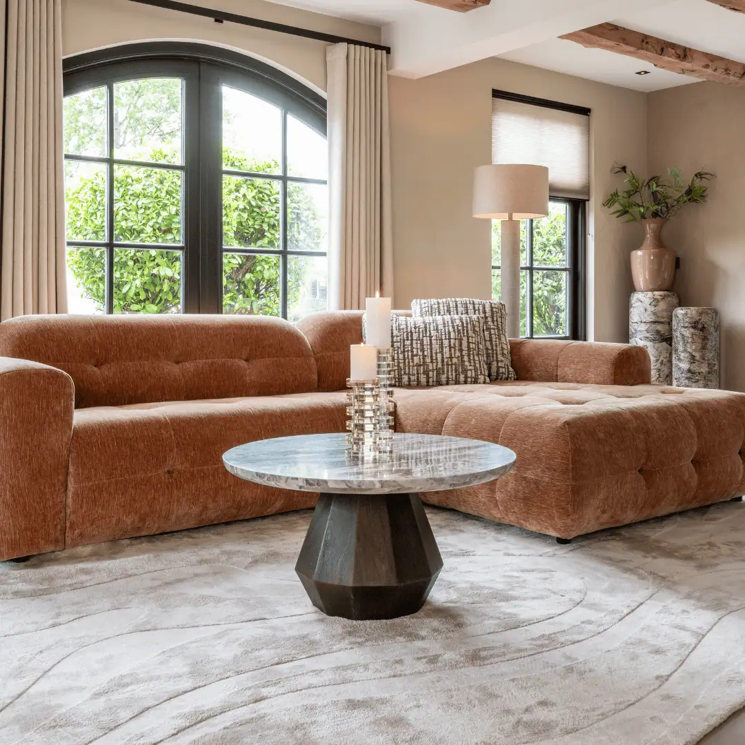 A modern living room with large windows, a rustic wooden ceiling, and stylish furniture.