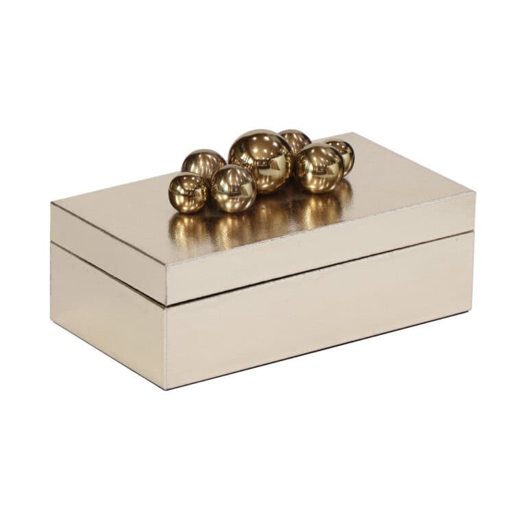 Gouden decoratieve ballen op een elegante opbergdoos.