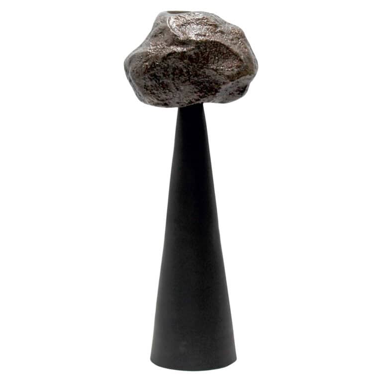 Moderne zwarte kandelaar met grote rots als decoratief element.