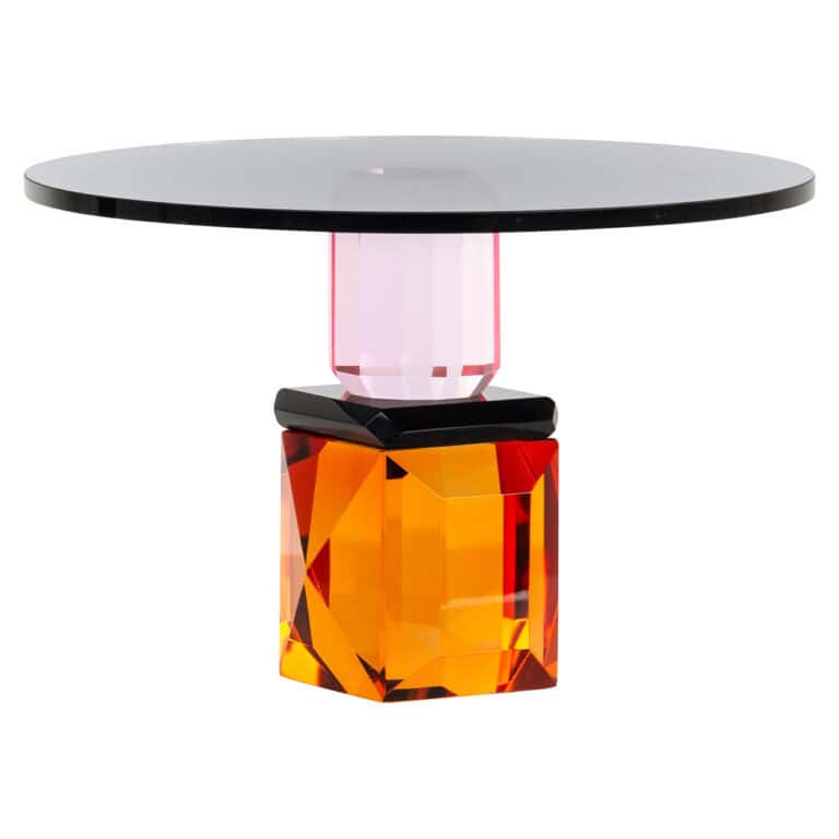 Moderne tafel met kleurrijk, geometrisch onderstel en ronde bovenkant.