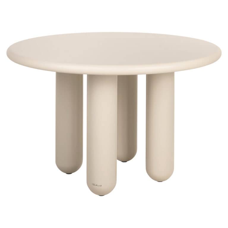 Table à dîner e moderne de couleur beige, de forme arrondie et dotée de pieds épais.
