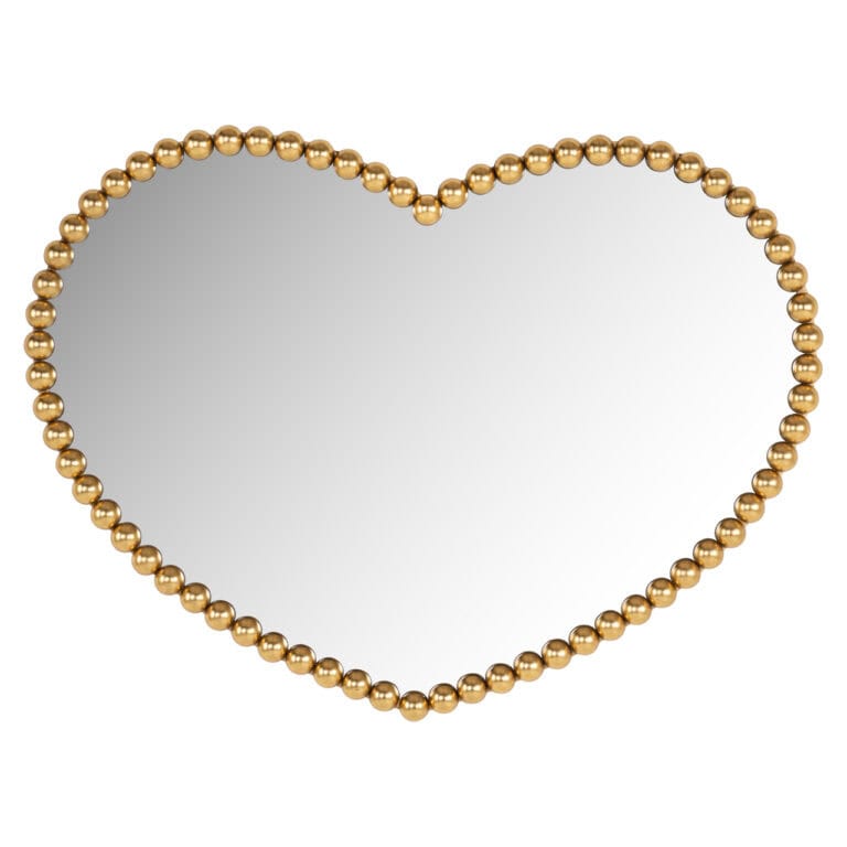 Miroir en forme de cœur, bordée de perles dorées à des fins décoratives.