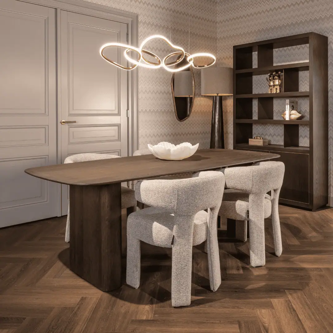 Dining area with a wooden table, beige chairs, and modern lighting.