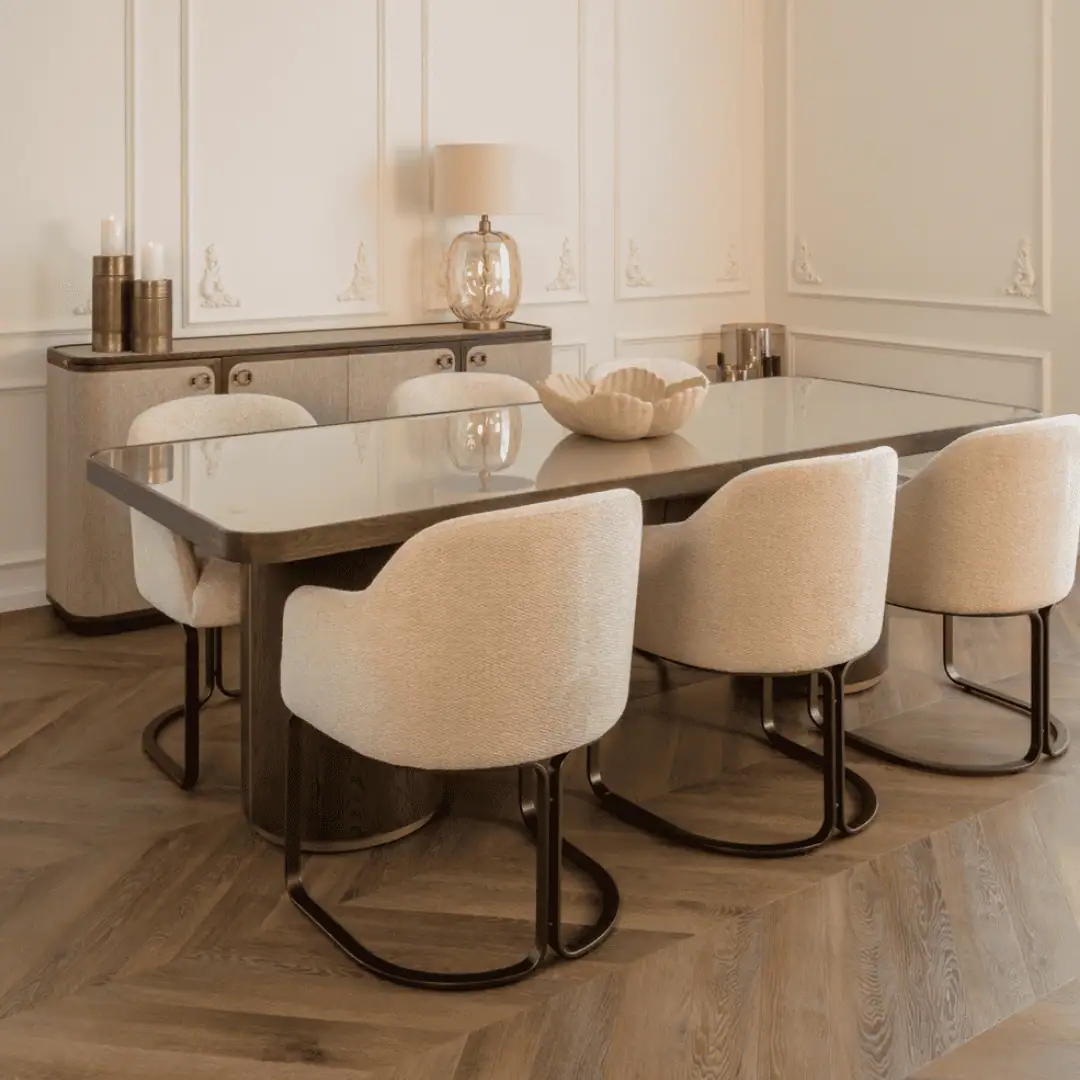 Salle à manger moderne avec des chaises beiges et une table en verre.