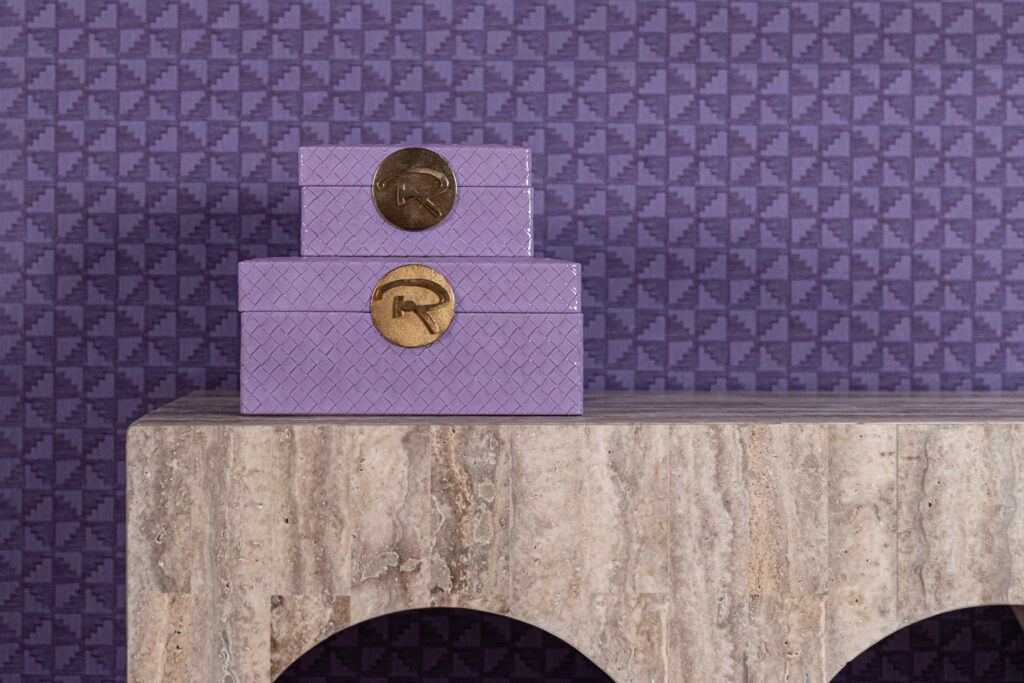 Boîte de rangement violette « Joelle » ornée des logos R et C dorés, posée sur une table en marbre.